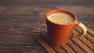 قهوه در لیوان نارنجی برروی میز